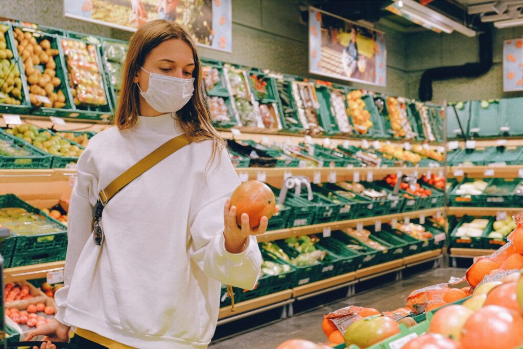 woman with face mask holding a apple, bdr group